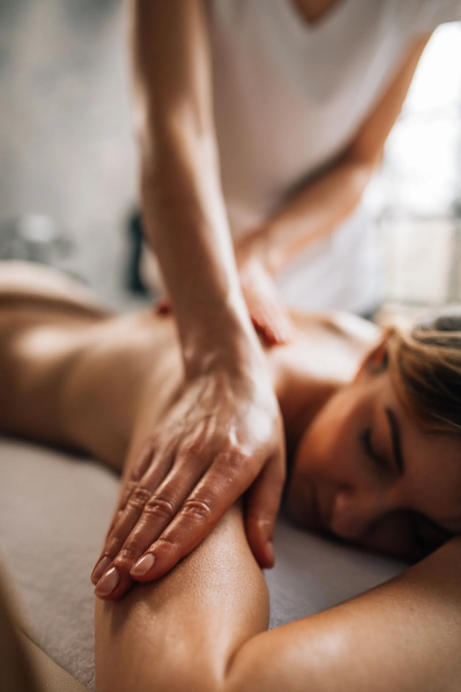 A therapist working on a client's shoulder during a session