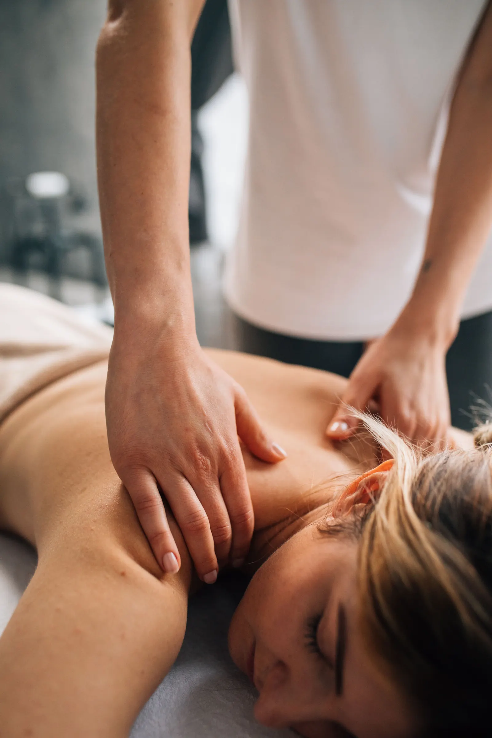 A therapist working on a client's neck and shoulder during a session