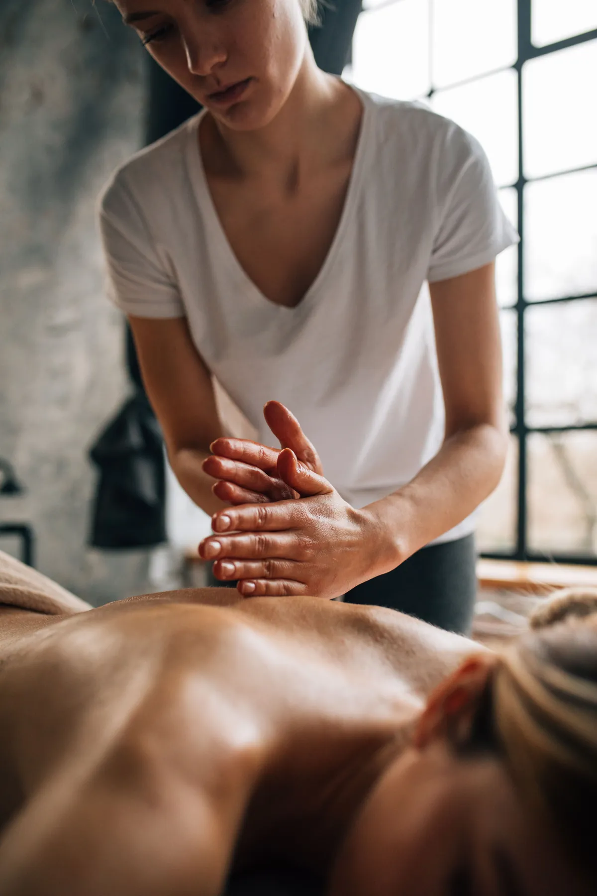 Maren working on a client's back in the treatment room