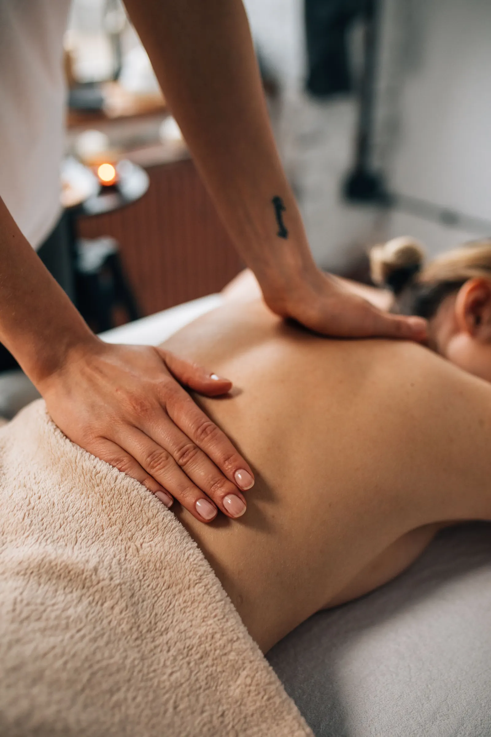 A therapist working on a client's back during a session