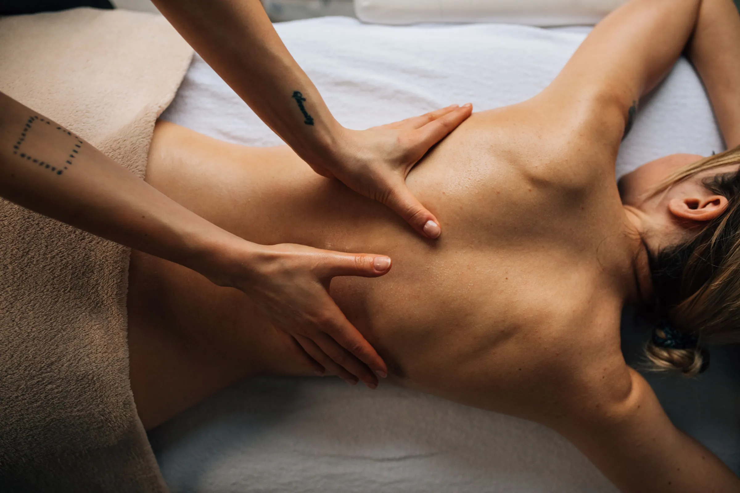 A licensed therapist working on a client's upper back during a session